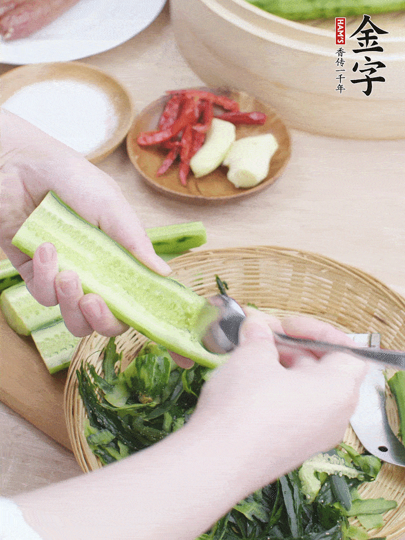 黃瓜削皮，對(duì)半切開(kāi)，勺子挖去內(nèi)瓤，斜刀切片。青蒜斜刀切段。